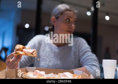 https://l450v.alamy.com/450v/2b6df4k/beautiful-woman-eating-pizza-and-drinking-cola-while-sitting-inside-expres-restaurant-late-at-night-2b6df4k.jpg