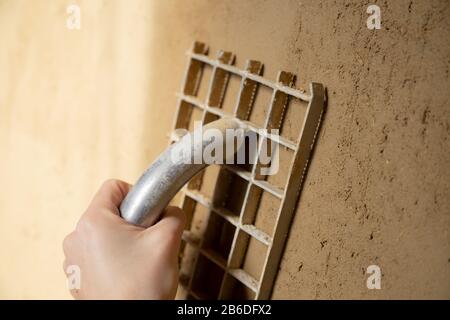 Closeup of a plasterer finishing a wall made of clay plaster with a board Stock Photo