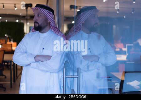Modern Arabic businessman in tradition suit standing and  thinking about new projects and investments in the future. Stock Photo