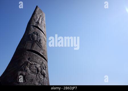 A closed up view of Bronze monument of Sail of Columbus commemorates the 500th anniversary of Christopher Columbus sail to America with the skyline of Lower Manhattan of New York City in background.Liberty State Park.New Jersey.USA Stock Photo