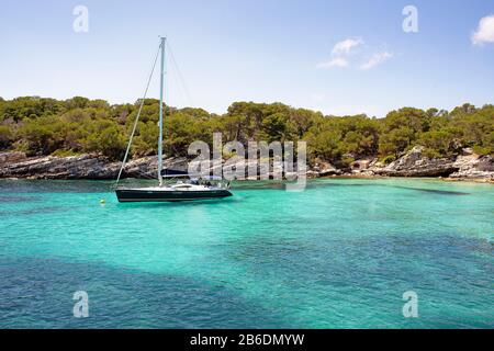 A yatch standing in Cala Macarelleta in Menorca island, mediterranean sea, Spain Stock Photo