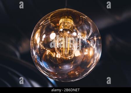 Giant vintage style light bulb with its retro filaments visible inside Stock Photo