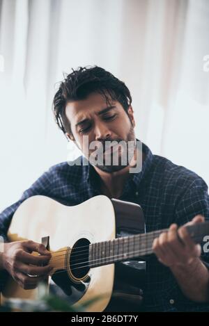 Practicing in playing guitar. Handsome young men playing guitar Stock Photo