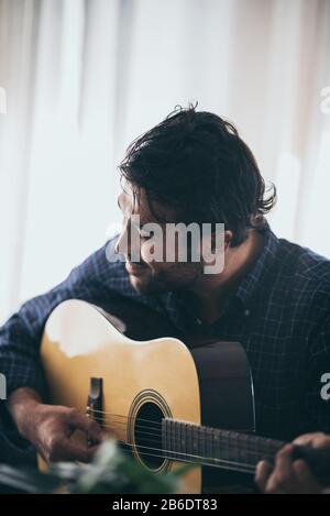 Practicing in playing guitar. Handsome young men playing guitar Stock Photo