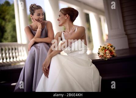 An attractive bride engaged in a pleasant conversation with her friend. Stock Photo