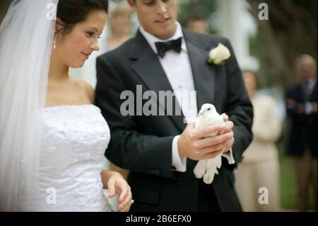 Young adult bride and groom releasing doves on their wedding day. Stock Photo