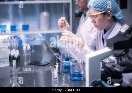 In a Modern Laboratory Scientists team Conduct Experiments, Consisting of glassware  test tubes and microscopes Stock Photo