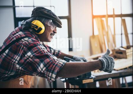 old carpenter man working in carpenter studio Stock Photo