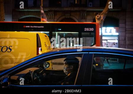 Barcelona, Spain. 10th Mar, 2020. A man wearing a sanitary mask inside his parked vehicle as a preventive measure against the corona virus.The coronavirus continues to spread in Spain. Some merchants from the Chinese community that run shops, bars and restaurants in Barcelona have decided to close their commercial activities and initiate a voluntary quarantine due to the expansion of Covid-19 in the Catalan community. Credit: SOPA Images Limited/Alamy Live News Stock Photo