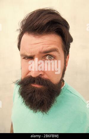 Suspicious look. Perceptions of male beauty. Stylish beard and mustache care. Strict face. Beard fashion barber. Handsome guy. Masculinity concept. Man bearded hipster stylish beard grey background. Stock Photo