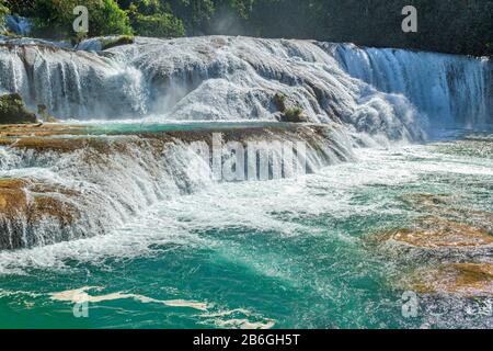 The turquoise waters of Agua Azul waterfall flowing with force creating a lot of spray in the air in the rainforest of Chiapas near Palenque, Mexico. Stock Photo