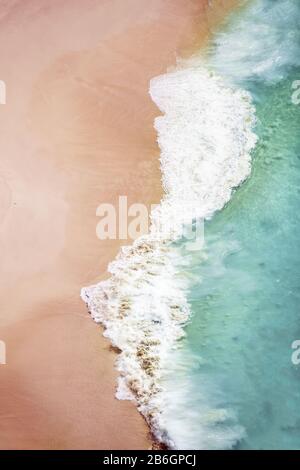 View from above, stunning aerial view of a beautiful beach bathed by a turquoise sea during sunset. Kelingking beach, Nusa Penida, Indonesia. Stock Photo