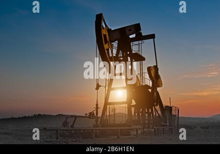 Oil pumps. Oil industry equipment. Oil rocking at sunset Stock Photo