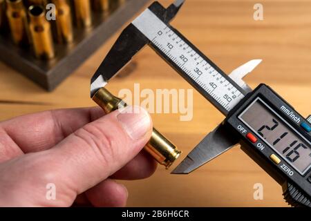 Production of cartridges for a rifle, reload. Measurement of the empty cartridges with a caliper Stock Photo