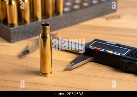Production of cartridges for a rifle, reload. Measurement of the empty cartridges with a caliper. Close up Stock Photo