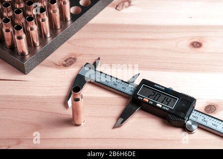 Production of cartridges for a rifle, reload. Measurement of the empty cartridges with a caliper Stock Photo