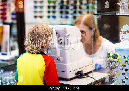 Kids eye sight test. Little boy at ophthalmologist office for eyes check up. Eyesight examination for young children. Doctor examining patient. Stock Photo