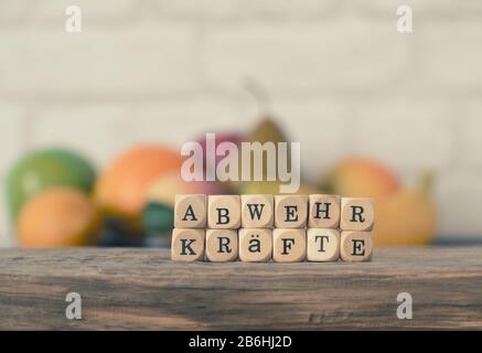 Wooden blocks with the German word 'immune system' in front of fresh fruit, healthy eating concept Stock Photo