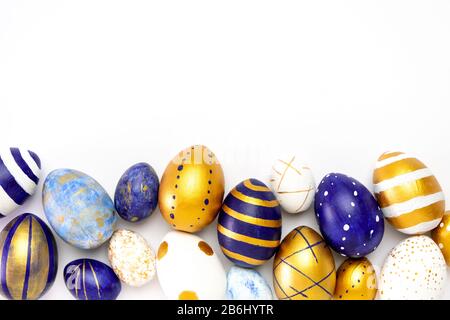 Happy Easter. Frame for text made of easter eggs trendy colored classic blue, white and golden on white. Minimal style, top view, flatlay, copy space. Stock Photo
