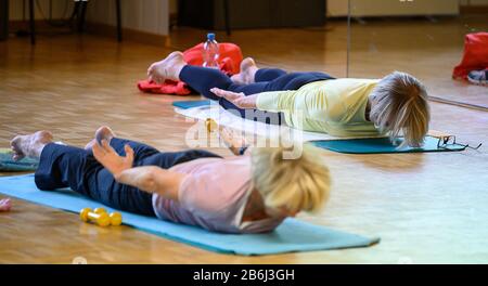 Stuttgart, Germany. 03rd Mar, 2020. Two women do an exercise for the back muscles during a sports lesson for people over 60. Credit: Sebastian Gollnow/dpa/Alamy Live News Stock Photo