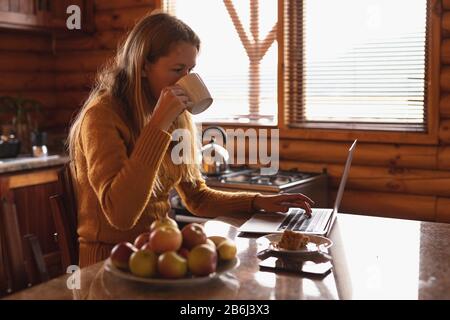 Caucasian woman works comfortably on her laptop Stock Photo