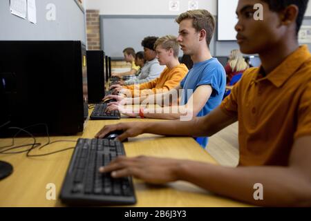 Side view of students working on computers Stock Photo