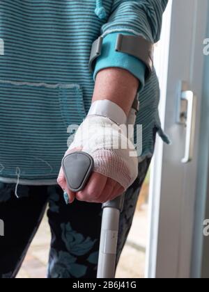Injured woman trying to walk on Crutches at home Stock Photo