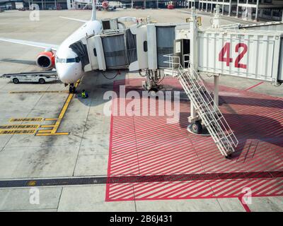 Bangkok, Thailand - February 5, 2019: Modern passenger airplane parked to terminal building gate no.42 on airport building background in Don Mueang In Stock Photo