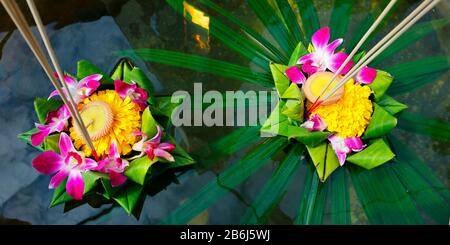 krathong ,hand crafted floating basket by banana leaf,decorated with flowers and incense sticks, candle,light and float on water to celebrate festival Stock Photo