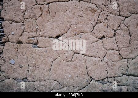 Fractured cracked surface of mud daub plaster on an old wall in a close up full frame view Stock Photo