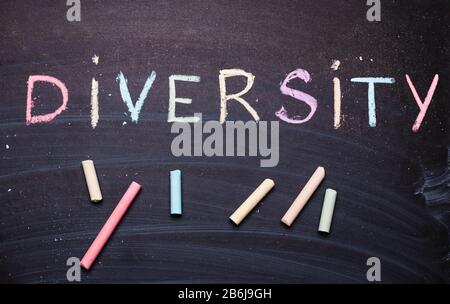 The word diversity is written in chalk on a blackboard. Stock Photo