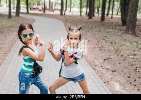 Two Stylish little girls in sunglasses having fun outdoor Stock Photo