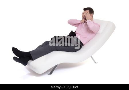 Man client sitting with psychologist on the comfortable couch during the psychological session, cat on lap Stock Photo