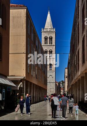 Zadar, Dalmatia province, Croatia, Pedestrians pass towards the belfry of romanesque cathedral of St Anastasia Stock Photo