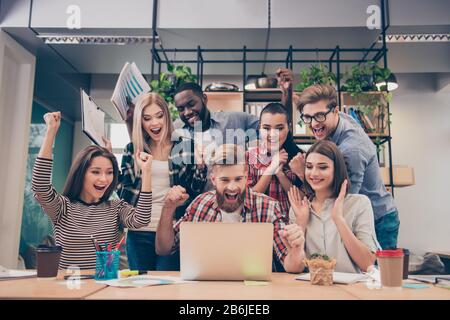 Yes! Happy multinational young managers successfuly completed hard project Stock Photo