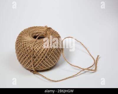 a partly uncoiled  ball of string isolated on white background Stock Photo