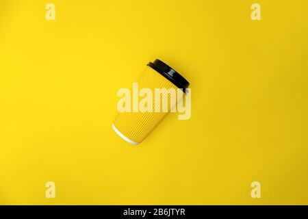 Yellow coffee paper cup with cap are on yellow background Stock Photo