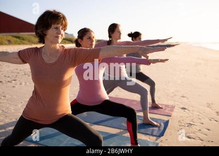 Side view of women on yoga mat stretching Stock Photo