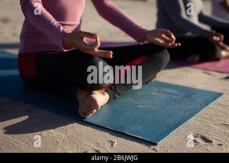 Close up view of woman doing yoga at the beach Stock Photo
