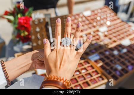 A woman trying on her new ring at outdoor flea handmade market, jewelry and shopping concept Stock Photo