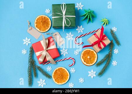 winter holidays, new year and christmas concept - gift boxes, fir tree branches, tags and decorations on blue background Stock Photo