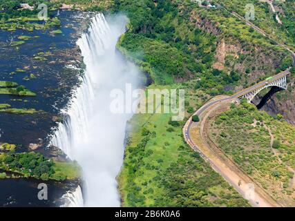 Aerial view of Victoria Falls located Zimbabwe and Zambia border, which can be crossed by bridge. Natural environment with Zambezi River waterfalls.