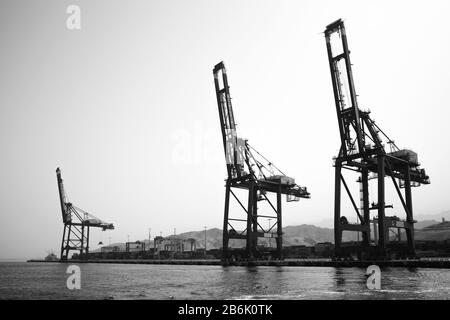 Aqaba, Jordan - May 18, 2018: Gantry cranes are in Aqaba container terminal, black and white silhouette photo Stock Photo