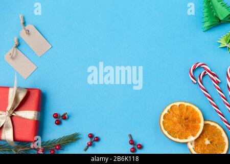 winter holidays, new year and christmas concept - gift box, fir tree branches, tags and decorations on blue background Stock Photo