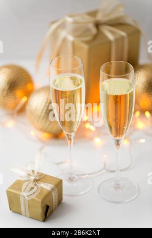 christmas, holidays and celebration concept - two glasses of champagne, gifts and decorations Stock Photo