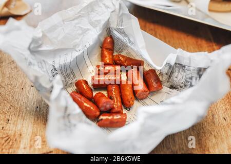 Appetizing grilled sausages with sauce on cafe table Stock Photo