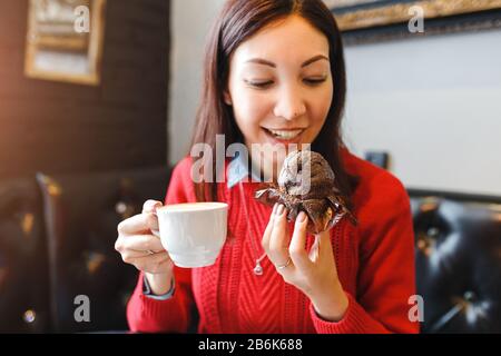 Young woman drinking coffee and eating a delicious muffin cake in retro cafe, breakfast and good morning concept Stock Photo
