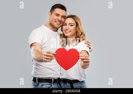 smiling couple holding big red heart Stock Photo
