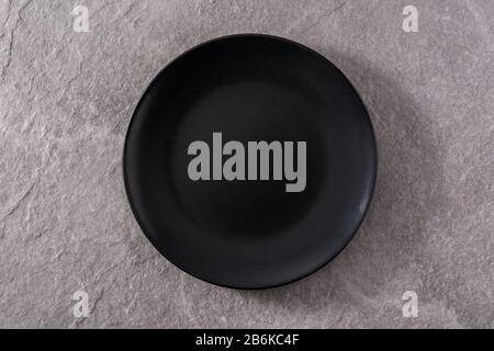 Empty black plate on gray slate background top view Stock Photo