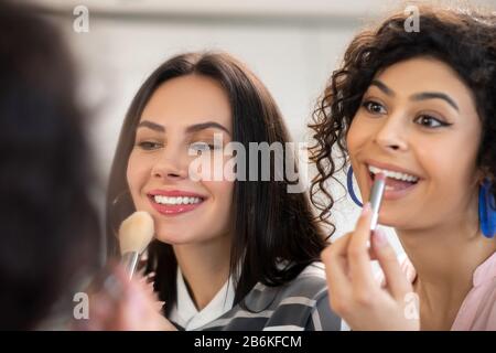 Two dark-haired women doing make up and feeling great Stock Photo